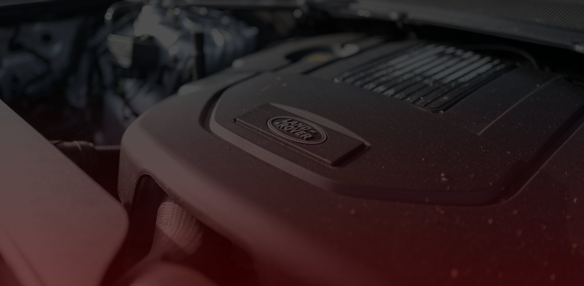 Close-up of a car engine with a focus on the Land Rover logo on the cover, expertly maintained by Bloor West Auto. The engine components are mostly in shades of black and gray, with the background slightly blurred. Euro Mechanic | Bloor West Auto Repair Mechanics | Top Reviewed Auto Repair Shop in Mississauga | Visit bloorwestauto.ca