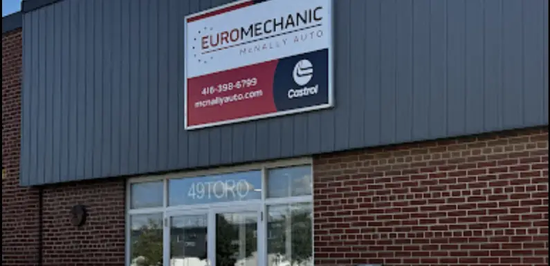 Front view of the building features a gray upper facade and red brick lower section. A sign reads Euromechanic McNally Auto with contact details, adding a touch of charm to this Bloor West Auto location. The glass entrance displays the number 491 invitingly. Euro Mechanic | Bloor West Auto Repair Mechanics | Top Reviewed Auto Repair Shop in Mississauga | Visit bloorwestauto.ca