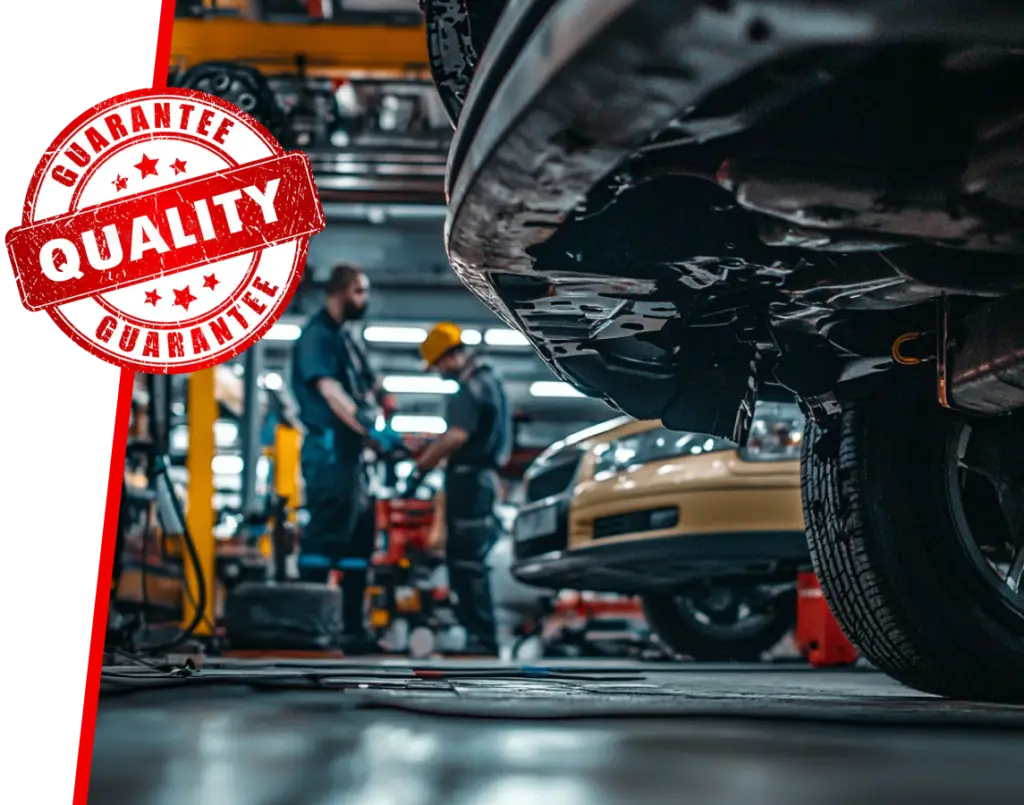 Close-up of a cars underside in a garage with two mechanics blurred in the background. The scene highlights Bloor West Auto EuroMechanics commitment, with a prominent, stylized Quality Guarantee stamp on the left side of the image. Euro Mechanic | Bloor West Auto Repair Mechanics | Top Reviewed Auto Repair Shop in Mississauga | Visit bloorwestauto.ca
