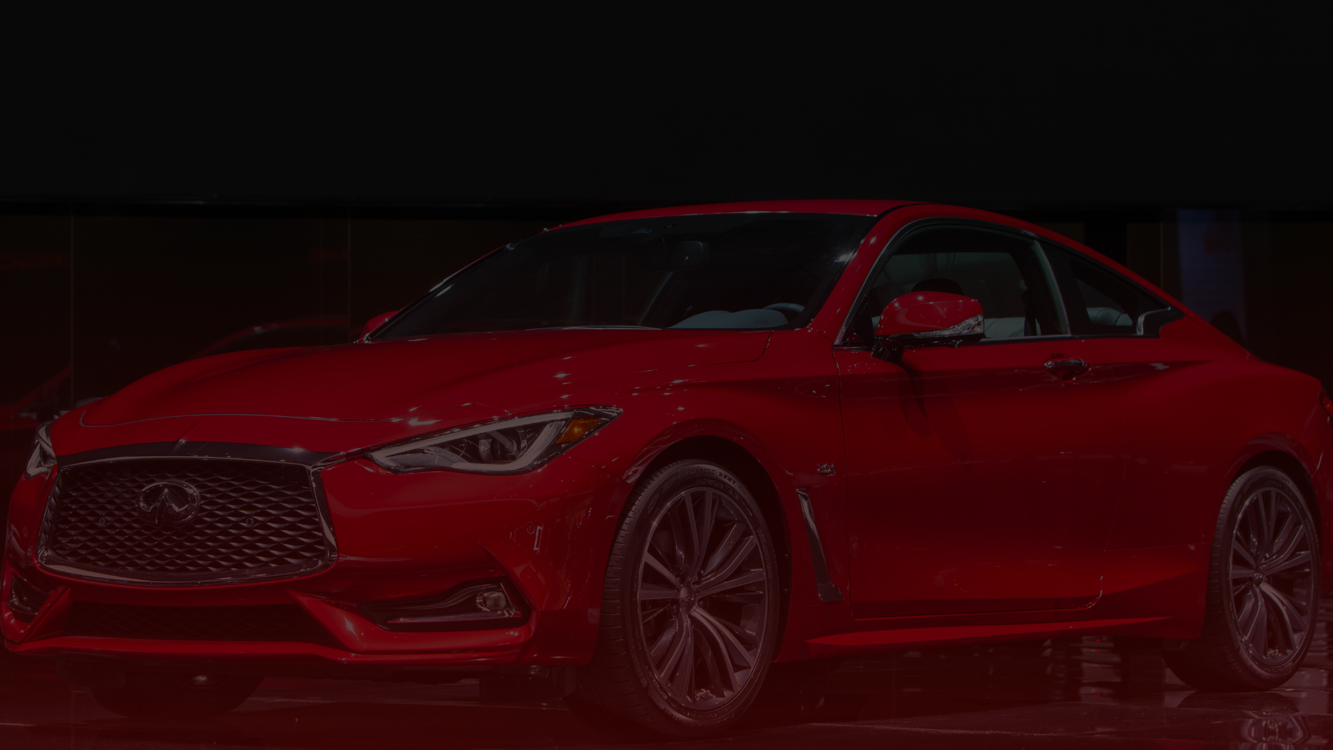 A sleek, red sports car with a stylish design is parked indoors at a top-tier Toyota Repair Mississauga center. The vehicle features a prominent front grille, sharp LED headlights, and alloy wheels, exuding elegance and speed against the dark background. Euro Mechanic | Bloor West Auto Repair Mechanics | Top Reviewed Auto Repair Shop in Mississauga | Visit bloorwestauto.ca
